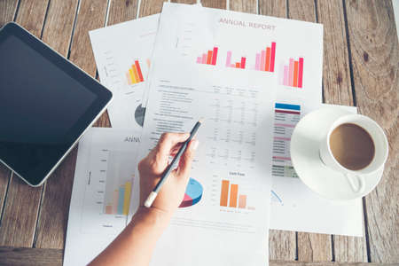 Office laptop business financial document chart and graph on wooden table with coffee cup. Flat lay notebook computer laptop on office desk. No people business graph chart mockup on business workspaceの写真素材