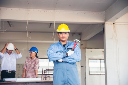 Construction engineer teamwork Safety Suit Trust Team Holding White Yellow Safety hard hat Security Equipment on Construction Site. Hardhat Protect Head for Civil Construction Engineer Conceptの写真素材