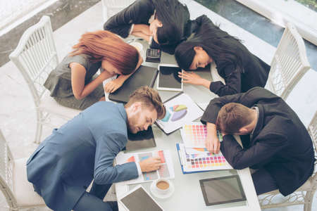 lazy tired team working until pass out. sleeping in conference room.の写真素材
