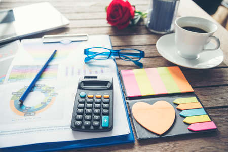 Office laptop business financial document chart and graph on wooden table with coffee cup. Flat lay...