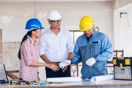 Construction engineer teamwork Safety Suit Trust Team Holding White Yellow Safety hard hat Security Equipment on Construction Site. Hardhat Protect Head for Civil Construction Engineer Conceptの写真素材