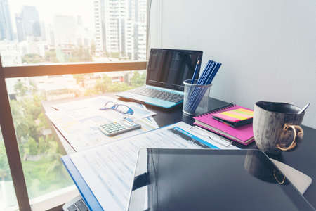 Office laptop business financial document chart and graph on wooden table with coffee cup. Flat lay notebook computer laptop on office desk. No people business graph chart mockup on business workspaceの写真素材