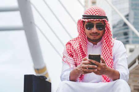 Islamic man using smartphones app organize schedule agenda  focus on hands holding smartphone muslim...