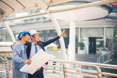 Civil engineer teams meeting working together wear worker helmets hardhat on construction site in...