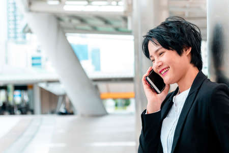 Business woman using smartphone shopping online, call, texting message internet technology lifestyle. Asian woman using cellphone walking on city street. Smart phone smart confident woman modern cityの写真素材