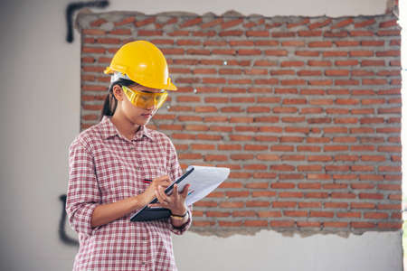 Woman construction engineer wear safety white hard hat at construction site industry worker. Female...