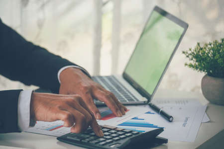 Close up business man hands using calculator counting tax financial bill. Man hands calculating...