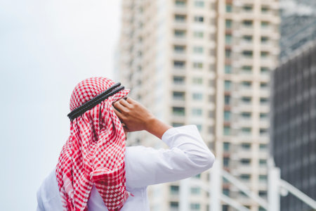 Islamic man using smartphones app organize schedule agenda  focus on hands holding smartphone muslim modern uae city. Arab men wear hijab and muslim formal dress sending text sms online lifestyleの写真素材