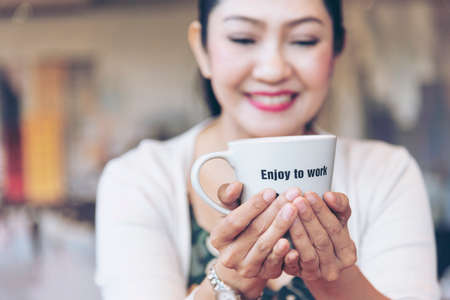 Woman holding coffee cup relaxing after work at office warm taste in cafe. Close up hands of woman...