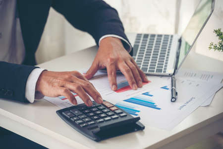Close up business man hands using calculator counting tax financial bill. Man hands calculating...