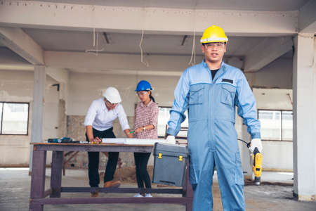 Construction engineer teamwork Safety Suit Trust Team Holding White Yellow Safety hard hat Security Equipment on Construction Site. Hardhat Protect Head for Civil Construction Engineer Conceptの写真素材