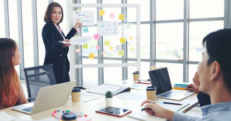 Happy business people meeting present graph chart investment, business data in meeting room. Group...