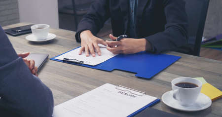 Two Businessman signing contract document start business agreement dealing teamwork. Close up hand young man colleagues  meeting mergers and acquisitions business. Partners Signed document at office.の写真素材