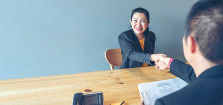 Businessman job interview by human resource HR officer interviwing, talk new employee shaking hands in office with smiling face. HR Manager interview check resume, face to face. Job Interview Conceptの写真素材