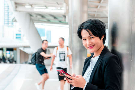 Business woman using smartphone shopping online, call, texting message internet technology lifestyle. Asian woman using cellphone walking on city street. Smart phone smart confident woman modern cityの写真素材