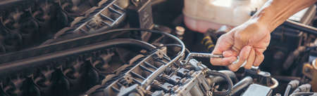 Banner Man hands fixing Car machinery vehicle mechanical service. Mechanic man hands repairing car shop. panoramaopen vehicle hood checking up auto mobile. Car maintenance engineer with copy sapce.の写真素材