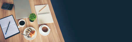 Banner Office laptop business financial document chart and graph on office wooden table coffee cup. Panorama Flat lay notebook computer laptop on office desk. Business stuff mockup with copy spaceの写真素材