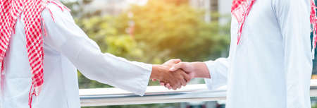 Banner Arab Businessman Muslim dress shaking hands together. Panorama Muslim Men Teamwork business partner handshake teams Partnership. multiracial UAE diversity  people trust honesty with copy spaceの写真素材