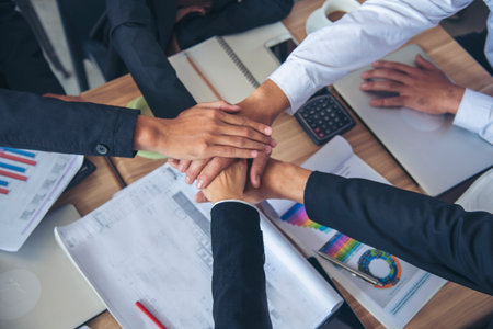 Partners hands together teamwork group of business people meeting in firm company office. Diversity...