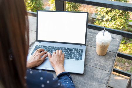 Close up women hands using laptop sitting at coffee shop garden. Top view Freelance woman working type computer keyboard Blank screen. Empty Screen laptop Blogger Woman hands typing computer keyboardの写真素材