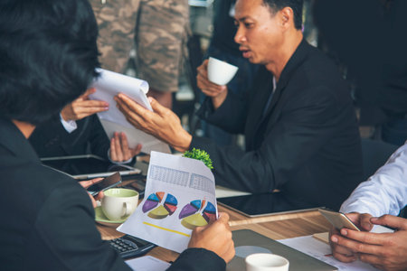 Creative design office center working teamwork. Happy business people partner plan strategy organization research people together at diversity office using laptop, smartphone company conference roomの写真素材