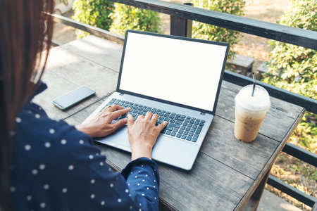 Empty Screen laptop Blogger Woman hands typing computer keyboard. Close up women hands using laptop sitting at coffee shop garden. Top view Freelance woman working type computer keyboard Blank screenの写真素材