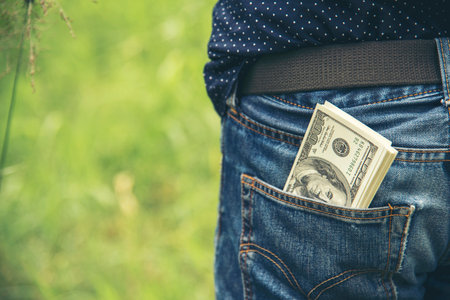 Hand holding money dollar bank note in wallet give financial payment. Man hands showing spread 100 dollar exchange cash payout. Saving Businessman counting money banknote bribe corruption concept.の写真素材