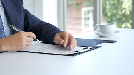 Businessman hand using pen signing on new contract to starting projects in conference room. Close up business manager man hands sign contract legal document in meeting room. Business agreement conceptの写真素材