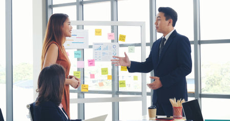 Happy business people meeting present graph chart investment, business data in meeting room. Group of business people meeting in conference room. Asian businessman speech, present teamwork partnershipの写真素材