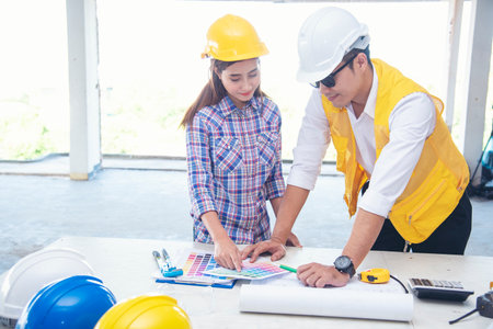 Civil engineer teams meeting working together wear worker helmets hardhat on construction site in modern city. Foreman industry project manager engineer teamwork. Asian industry professional teamの写真素材