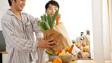 Asian people happy time smile, laugh in kitchen. Best friend LGBTQ lifestyle. Happy Asian gay couple homosexual cooking together in kitchen prepare fresh vegetable make organic salad healthy food.の写真素材