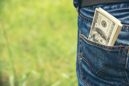 Hand holding money dollar bank note in wallet give financial payment. Man hands showing spread 100 dollar exchange cash payout. Saving Businessman counting money banknote bribe corruption concept.の写真素材