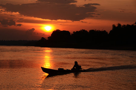 Silhouette tranquil season wilderness serene landscape. Tranquil lake countryside sunrise seaside reflection. Tropical amazing dramatic golden sky on sunset over scenic river lake seascape ocean.の写真素材