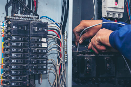 Inspector men hands working switchboard machinery maintenance service. Electrical mechanic technician check wire electric cabinet.  Electrician circuit repair voltage operation. Men hands fix breakerの写真素材