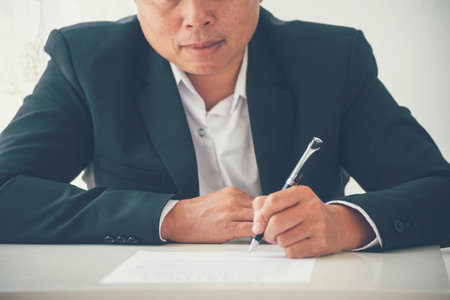 Businessman hand using pen signing on new contract starting projects in conference room. Close up business manager man hands sign contract legal document in meeting room. Business agreement conceptの写真素材