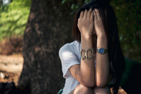 Recession Stress Woman using laptop work hard at home office outdoor in green park. Young women have headache, depressed from failure business burnout. Tired Asian woman despair sadness problemsの写真素材