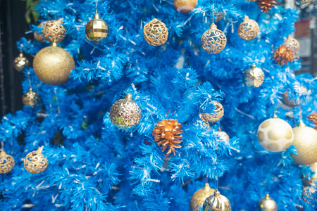 Blue golden glittering baubles xmas ornament ball decorated on christmas tree. Seasonal holiday winter xmas happy new year festival celebration. Blurred background Light gold ball Blue Christmas treeの写真素材