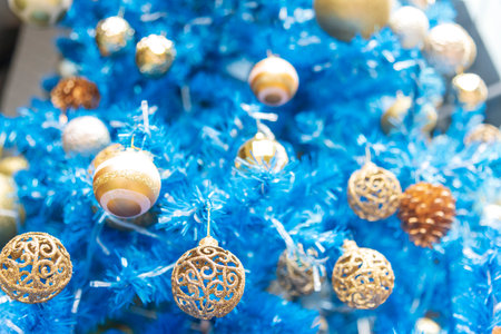 Blue golden glittering baubles xmas ornament ball decorated on christmas tree. Seasonal holiday winter xmas happy new year festival celebration. Blurred background Light gold ball Blue Christmas treeの写真素材