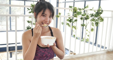 Women hands holding white glass of milk pouring from bottle. Asian women smile laugh look at camera health care home fitness lifestyle. Beautiful female drinking fresh milk low-fat dairy free lactoseの写真素材