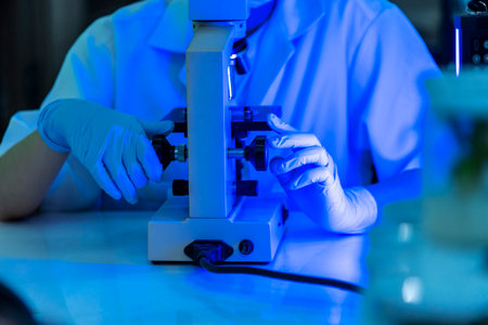Female technician laboratory analyze genetic research. Woman scientist in lab look at science microscope medical test researching biology chemistry in blue light black background. Chemistry Medicalの写真素材