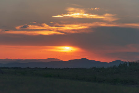 Sunset mountain range beautiful landscape mist, dusk golden time dramatic sky. Beautiful landscape high mountain ridge mist panning panorama scenery dawn dramatic sky. Sunrise landscape mountain peak.の写真素材
