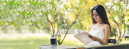 Banner woman holding book reading magazine at green park natural garden. Young woman relaxation read open book self study. Happiness University women smiling. Women sit in green park with copy spaceの写真素材