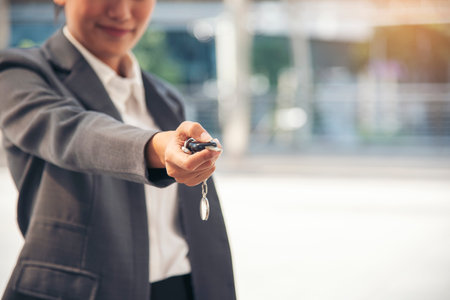 Close up hands of young woman showing key of new car.の写真素材