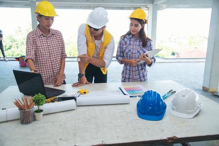 Civil Construction engineer teams shaking hands together wear work helmets worker on construction site. Foreman industry project working engineer teamwork. Two asian engineer team shake hands togetherの写真素材