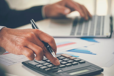 Close up man hands Asian businessman  calculating number, audit planning on business report Asian Business man hands using calculator counting tax financial bill. Tax audit Finacial conceptの写真素材