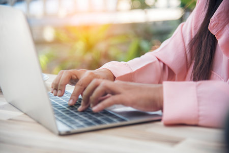 Woman typing laptop computer online meeting at home office work from home. Asian business woman using notebook laptop lifestyle. Happy programmer woman typing keyboard laptop read online websiteの写真素材