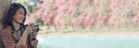 Banner Asian Women with vintage film camera in nature park with copy spaceの写真素材