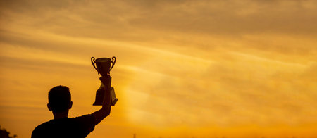 Banner Winner hands holding golden champion trophy cup prize