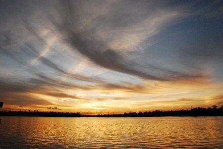 Scenic view dramatic beautiful sunset sky. Natural Sunset Sunrise on meadow silhouette shadow dark land. Vibrant dramatic sky on sunset, dawn, sunrise in Countryside. Landscape Colorful Sky At Sunsetの写真素材