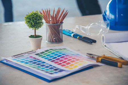 construction engineer office desk architect workplace. engineer drawing objects table with meter, blueprint, hard hat engineering stuff on desk. Designer Objects drafting workplace on wooden table.の写真素材